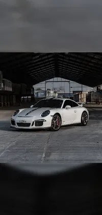 This dynamic live wallpaper features a sleek white sports car, a stunning Porsche GT 3, parked in a busy Hawaiian city lot