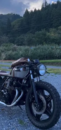 This motorcycle live wallpaper depicts a cafe racer parked on a rocky road
