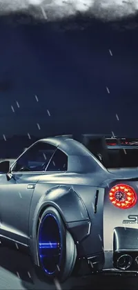This dazzling phone live wallpaper features a stunning silver sports car speeding down a winding road at night