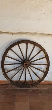 This phone live wallpaper showcases a rustic wooden wagon wheel against a pristine white wall