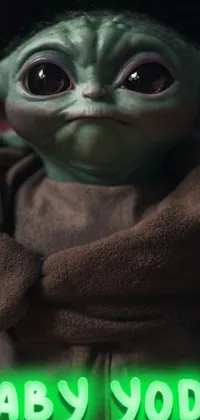 This phone live wallpaper showcases a captivating close up of a baby yoda doll