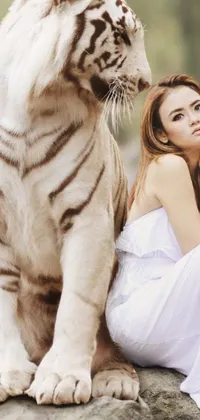 This stunning phone live wallpaper showcases a breathtaking image of a woman seated beside a regal white tiger