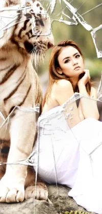 This live wallpaper showcases a serene scene featuring a beautiful woman dressed in white, sitting calmly alongside a majestic white tiger