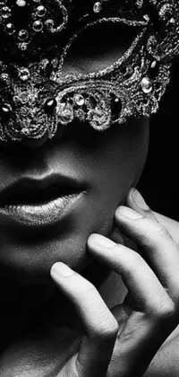 Looking for a unique and seductive live wallpaper for your phone? This black and white photo features a bedazzled, intimately holding close individual wearing a mask