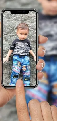 This phone live wallpaper showcases a beautiful hyperrealistic painting of a person taking a photo of a baby on their cell phone