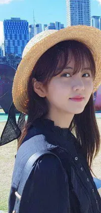 This live phone wallpaper features a close-up portrait of an attractive youthful woman wearing a hat and showcasing long straight bangs