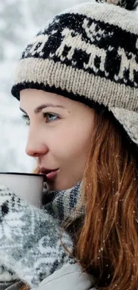 This phone live wallpaper showcases a stunning digital art portrait of a woman enjoying a warm cup of coffee amidst a serene snow landscape