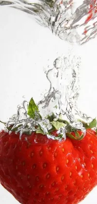 This live wallpaper showcases a stunning close-up view of a ripe strawberry being dropped into a pool of water