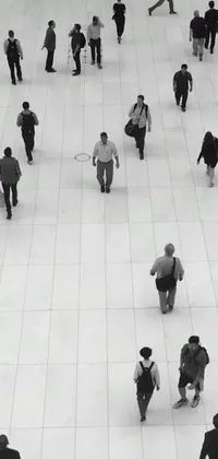 Looking for a stylish and minimalist live wallpaper for your phone? Check out this black and white crowd photo inspired by contemporary art! The image shows a group of people walking to work on a white tiled floor and is framed by square lines in shades of gray and black
