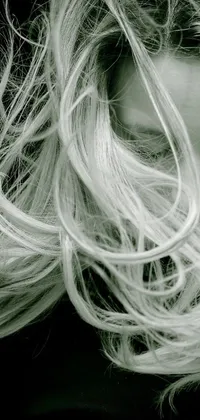 This live phone wallpaper features a monochrome, romanticism-inspired closeup of a person with long, wild hair