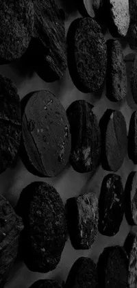 This phone live wallpaper depicts a striking black and white photograph of rocks on a wall, showcasing a raw and natural beauty