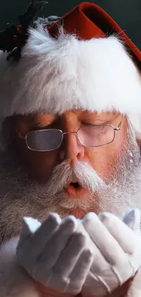 This phone live wallpaper features a real-life depiction of a festive Santa suit with a close-up of the figure wearing it