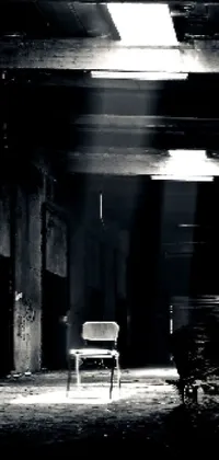 This Live Wallpaper features a black and white photograph of a chair in a dark room set against an industrial warehouse backdrop