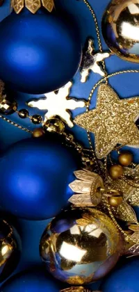 This elegant phone live wallpaper showcases a pile of blue and gold Christmas ornaments against a dark background, for a chic and festive look