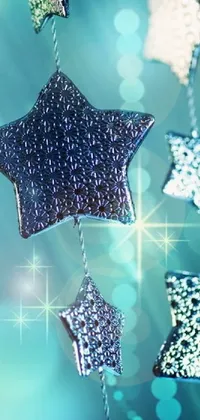 Transform your phone screen with this stunning live wallpaper featuring a collection of sparkling stars hanging from a thin silver string set against an alluring silver and blue color scheme