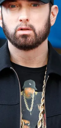 This phone live wallpaper is a hyper-realistic close-up of a stylish hat-wearing person sporting a black shirt with a gold chain and ice cube