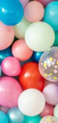 This lively phone live wallpaper showcases a bunch of colorful balloons and confetti spread across a table