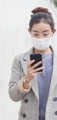 This live wallpaper features a stylish woman wearing a face mask as she checks her phone