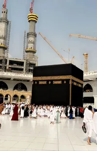 This mesmerizing <a href="/">phone live wallpaper</a> showcases a group of individuals standing near a building surrounded by hurufiyya with the imposing Ka&#39;bah in the background