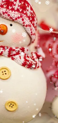Bring warmth and joy to your phone with this charming live wallpaper featuring two snowmen sitting closely together in a snow-covered wonderland