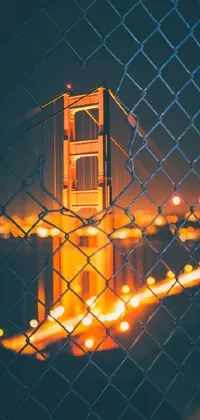 Experience the mesmerizing view of the Golden Gate Bridge through a chain link fence with this stunning phone live wallpaper by digital artist