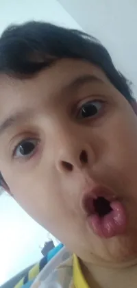 This live wallpaper for your phone features a young boy making a silly face by sticking his tongue out