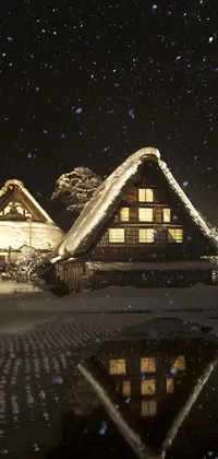 This live wallpaper depicts two thatched houses nestled in a snowy landscape