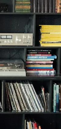 This phone live wallpaper features a record player atop an organized bookshelf displaying magazines and books