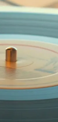 This dynamic phone live wallpaper showcases a close-up of a spinning vinyl record on a table