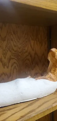 This live phone wallpaper showcases an intricate sculpture of a dog sitting atop a wooden shelf