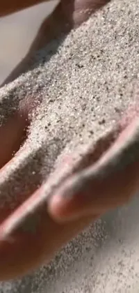 This phone live wallpaper showcases a beautiful close-up of hands holding sand, set against a gorgeous daylight backdrop