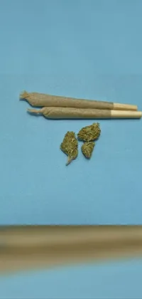 This live phone wallpaper depicts a still life scene of a pair of chopsticks atop a wooden table, surrounded by marijuana buds in high-quality detail