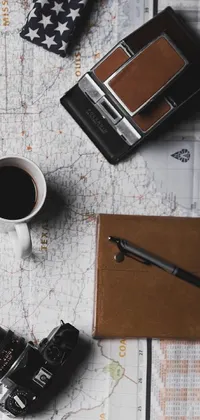 This stunning live wallpaper features a pair of brown shoes positioned on top of a vintage map surrounded by various items, including a coffee cup, a pen, and a notebook