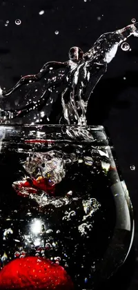 This live wallpaper for your phone features a stunning image of a strawberry splashing into a bowl of water, adding a dynamic touch to your device's home screen